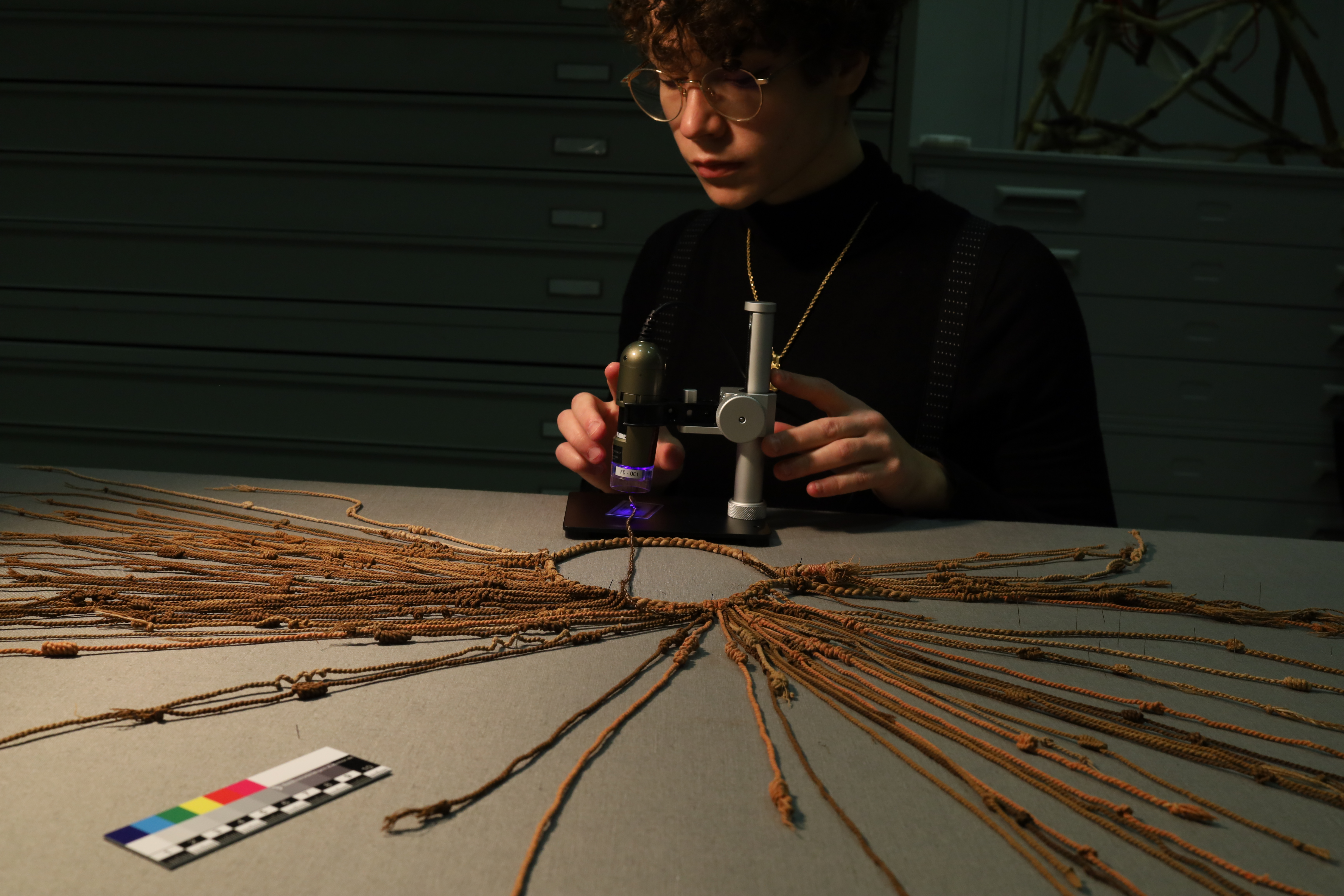 Lucrezia studying a khipu with a USB microscope